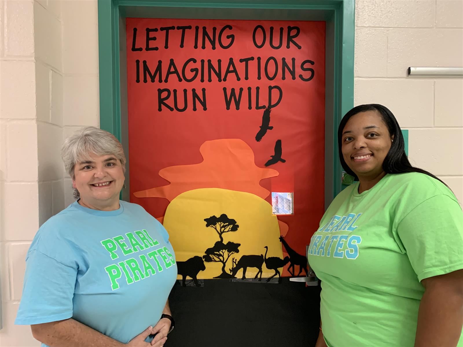 Mrs. Farrar & Mrs. Hoard in front of their classroom door.